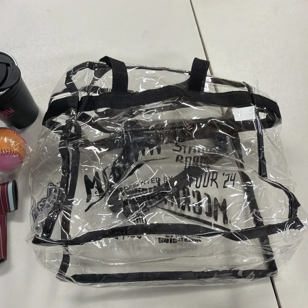collection of McGraw-branded tour merchandise, including a clear tote bag 2024